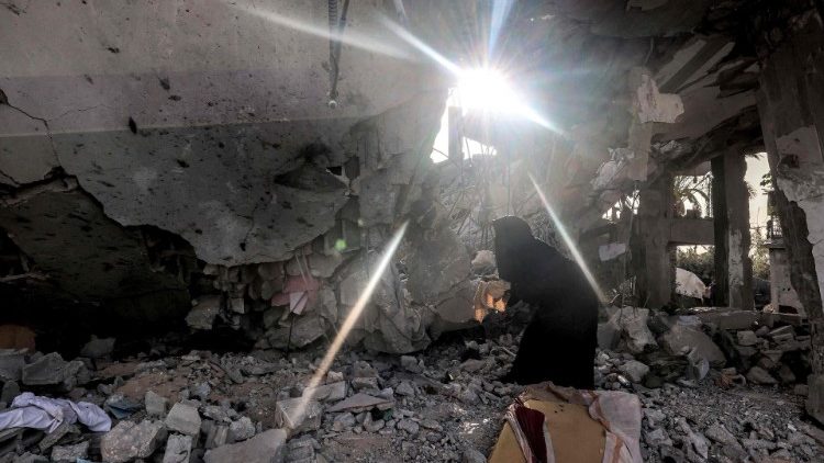 Eine Frau durchsucht die Überreste eines zerstörten Hauses in Rafah 