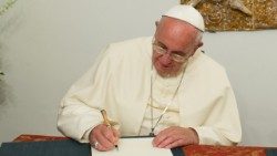 El Santo Padre Francisco firma un documento, foto de archivo