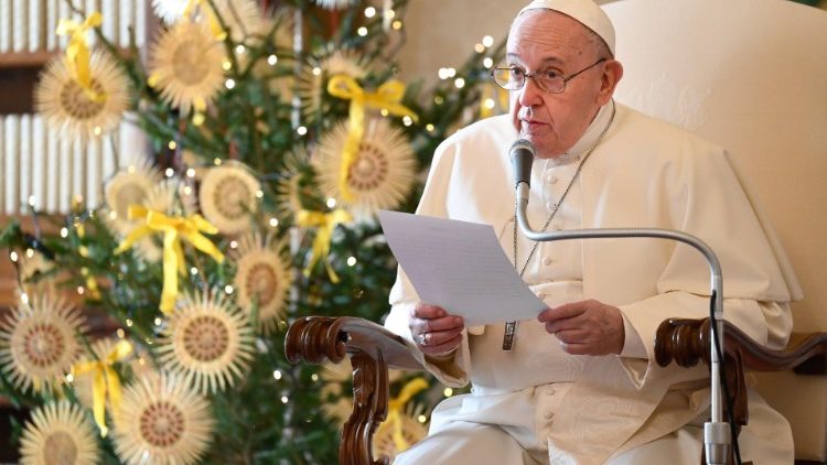 Papst Franziskus neben einem geschmückten Christbaum