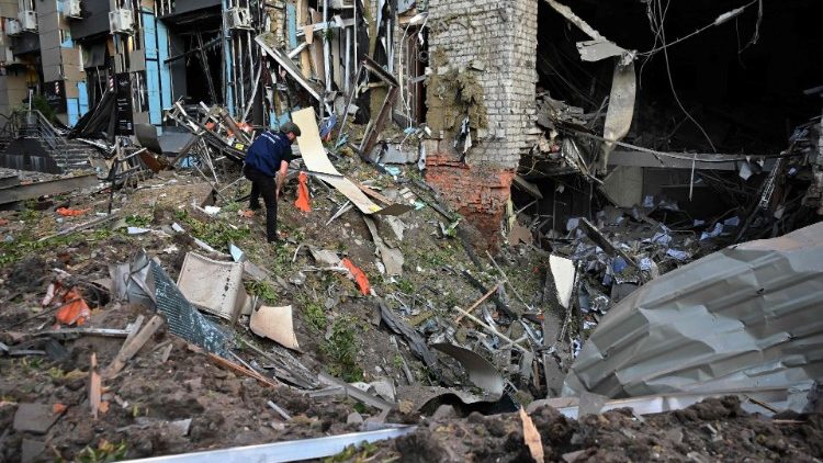 Um policial inspeciona um prédio de escritórios fortemente danificado após o ataque aéreo russo em Kharkiv, em 25 de maio de 2024, em meio à invasão russa da Ucrânia. Outro ataque atingiu o centro de Kharkiv, ferindo 14 pessoas em uma área onde estão localizados um correio, um cabeleireiro e um café, disse o prefeito da cidade, Igor Terekhov. (Foto de SERGEY BOBOK/AFP)
