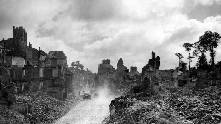 US armoured vehicles travel through the rubble-strewn streets of Saint-Lo, Normandy in 1944