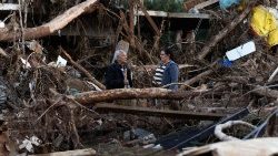 Pessoas conversam em meio a escombros e galhos de árvores no bairro Passo de Estrela, em Cruzeiro do Sul, Rio Grande do Sul, Brasil, em 5 de junho de 2024. (AFP/Silvio Avila)