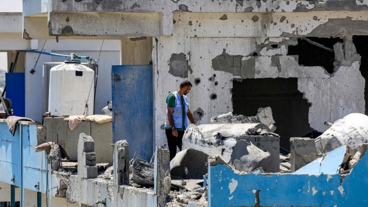 A UNRWA worker inspects damage to an UNRWA-run school in the Nuseirat camp