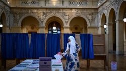 Una mujer coge papeletas para votar en las elecciones al Parlamento Europeo en un circuito de Lyon el 9 de junio de 2024. (AFP)
