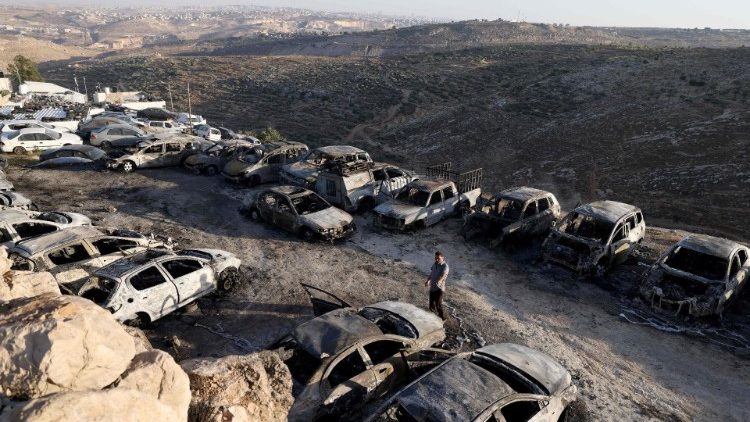 Burnt vehicles stationed in car park following an Israeli settlers attack in the town of Burqah in the West Bank