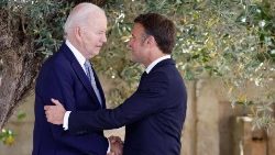 La stretta di mano tra il presidente statunitense Biden e quello francese, Macron (Afp)