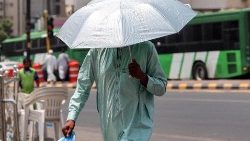 Ein Mann schützt sich in Mekka mit einem Regenschirm vor der Sonne 