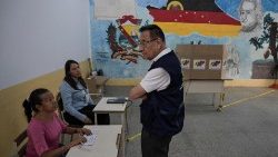 Membros da delegação internacional de observadores eleitorais visitam um dos principais centros de votação para verificar a instalação de seções eleitorais a serem usadas na eleição presidencial, em Caracas, Venezuela. (Foto de Yuri CORTEZ / AFP)