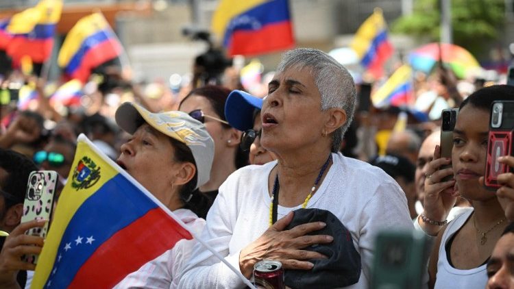 Venezuelans sing the national anthem at a demonstration in Caracas