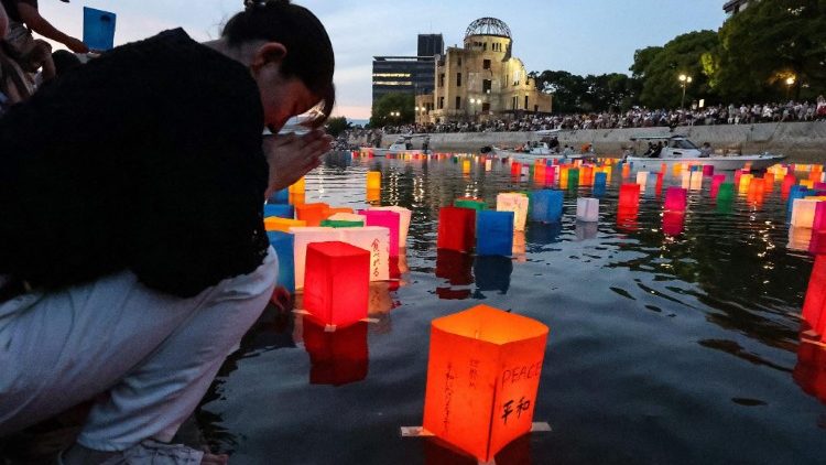 Una giovane in preghiera durante una manifestazione per la pace, in occasione dell'anniversario del bombardamento su Hiroshima e Nagasaki