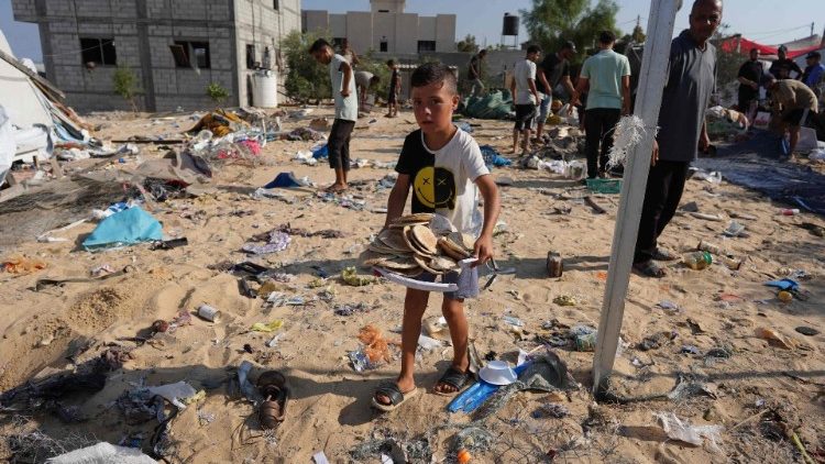 Ein Kind trägt Brot in einem Vertriebenencamp in Khan Yunis, Gazastreifen