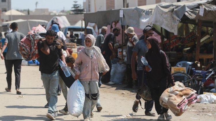 Palestinos huyen de un campamento improvisado para desplazados en Jan Yunis, en el sur de la Franja de Gaza, después de que los tanques israelíes tomaran posiciones en una colina que domina la zona, el 18 de agosto de 2024,