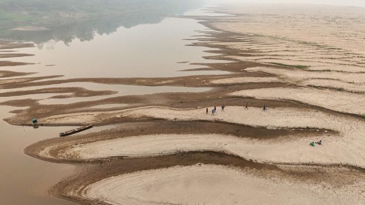 Pessoas carregam água potável ao longo de um banco de areia do Rio Madeira na Comunidade Paraizinho, em Humaitá, estado do Amazonas, em 7 de setembro