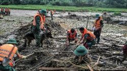 Rescue workers dig through debris at the site of a landslide in Vietnam's Lao Cai province