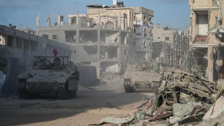 Isreali forces drive past destroyed buildings in Rafah in the Gaza Strip