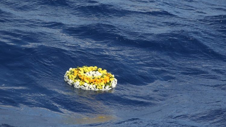 Una corona di fiori, omaggio per i migranti morti in mare