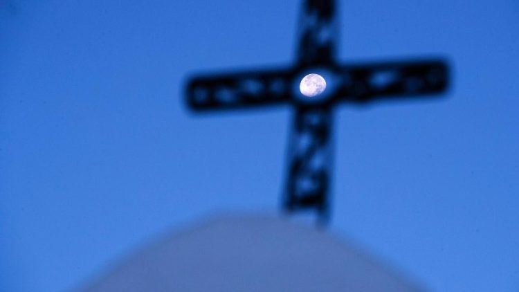 Mond, gesehen durch ein Kirchturmkreuz