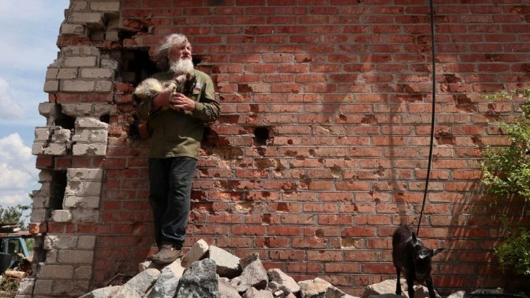 O morador local Viktor, 67 anos, segurando uma cabra nos braços, está sobre os escombros de um prédio danificado em Orikhiv, perto da linha de frente na região de Zaporizhzhia, sudeste da Ucrânia. EPA/KATERYNA KLOCHKO