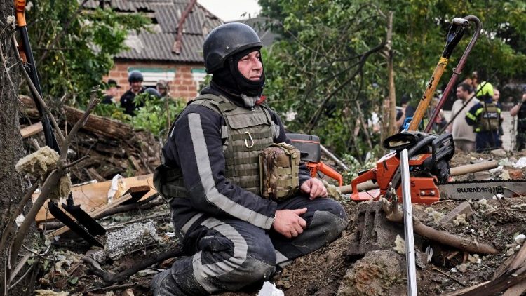 Um socorrista ucraniano descansa enquanto trabalha no local de um ataque com bomba plana em um prédio privado em Kharkiv, nordeste da Ucrânia, 10 de junho de 2024. EPA/SERGEY KOZLOV