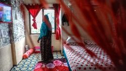 A Sudanese woman stands in a hotel recently converted into a temporary refugee shelter