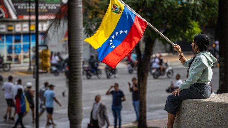 Caracas, una giovane con la bandiera del Venezuela