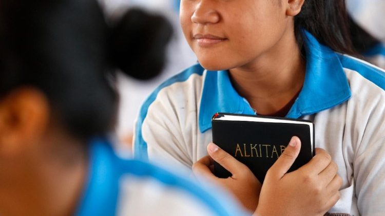 Indonesian Catholic holds a Bible