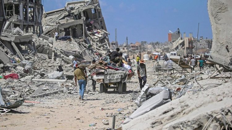 Palestinos deslocados internamente passam por suas casas destruídas enquanto retornam à cidade de Deir Al Balah depois que os militares israelenses retiraram as tropas do centro-leste da Faixa de Gaza, 29 de agosto de 2024