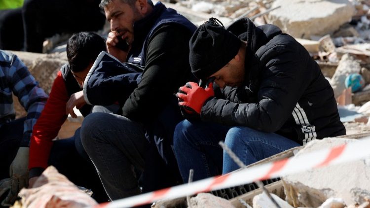 तुर्की के किरिखान में भूकंप के बाद खोये परिवारवालों के इंतजार में बैठे लोग