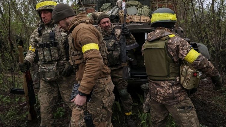 डोनेस्क क्षेत्र में फ्रंट लाइन के पास एक बीएमपी पैदल सेना से लड़ने वाले वाहन के बगल में यूक्रेनी सैनिक