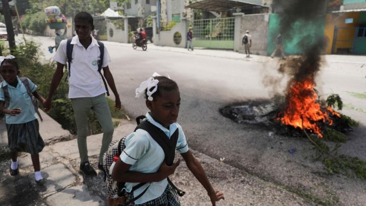 Menschen gehen während einer Demonstration in Port-au-Prince an brennenden Reifen vorbei