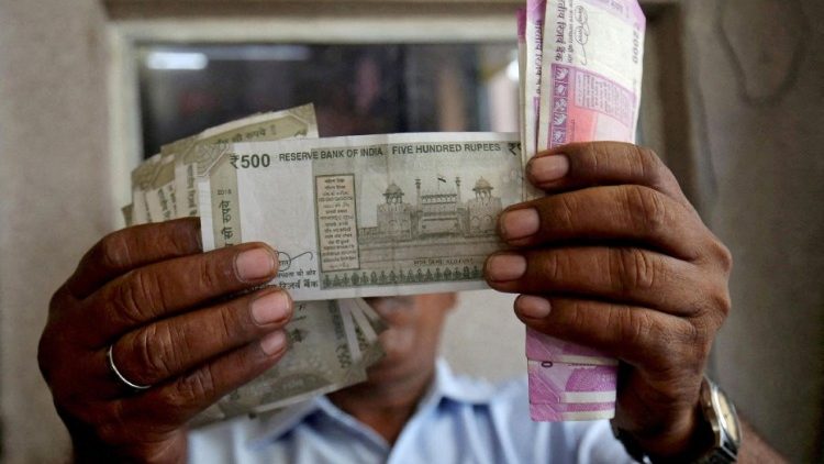 A cashier checks Indian rupee notes inside a room at a fuel station in Ahmedabad