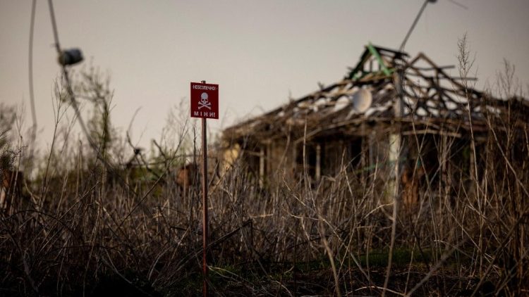 A sign warns of mines in the largely destroyed village of Dolnya, Ukraine