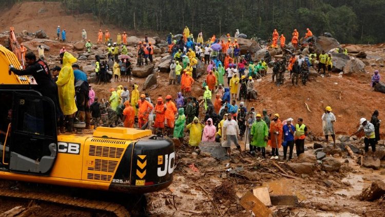 People watch as search operations are carried out after landslides hit Mundakkai village in Wayanad district in the southern state of Kerala