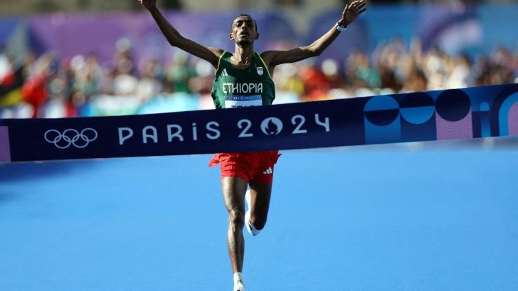 Tamirat Tola mentre taglia il traguardo alla maratona maschile