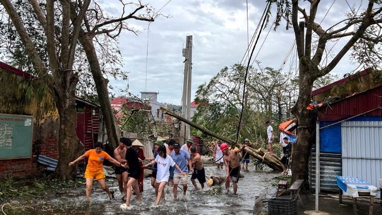 People in Vietnam clearing debris in the aftermath of floods caused by Typhoon Yagi