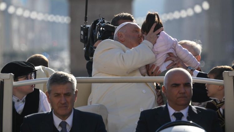 El Papa Francisco durante la audiencia general del 12 de abril besa a una niña presente en la plaza de San Pedro