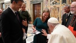 Ferenc pápa megáld egy várandós asszonyt, a Pápai Alapítvány egyik képviselőjét