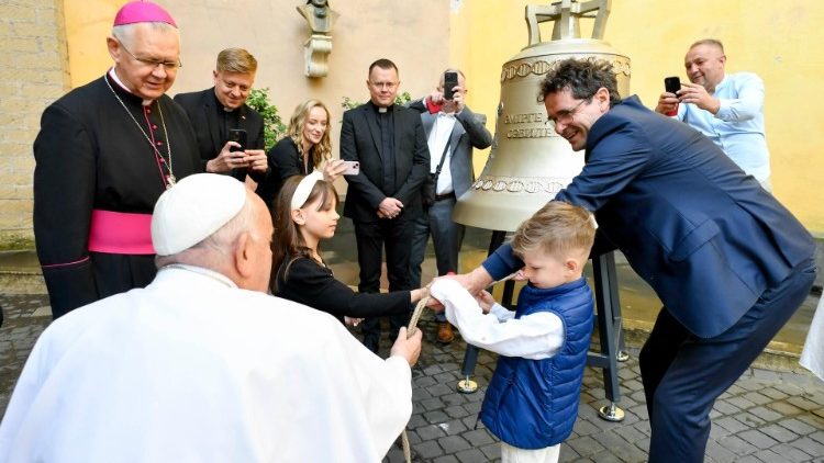 Le pape François et des enfants font tinter la cloche. 