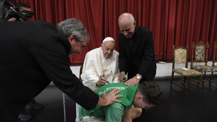 El Papa firma la camiseta obsequiada por los niños de la parroquia de santa Bernardita. (Vatican Media)