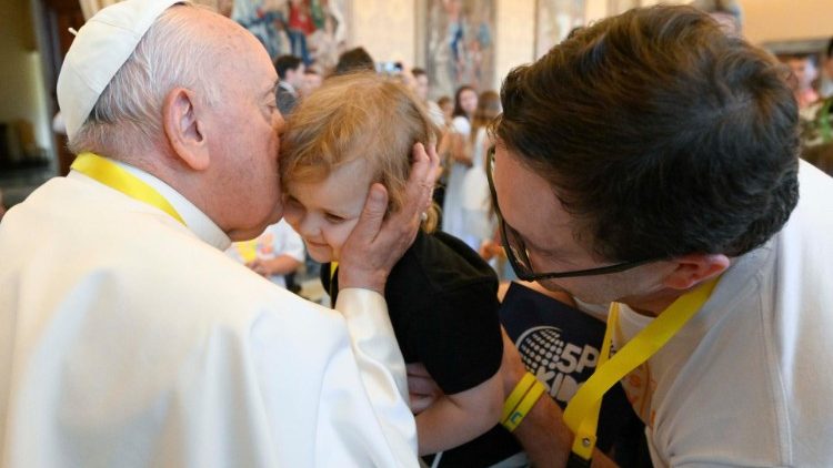 The Pope kisses a child during the meeting