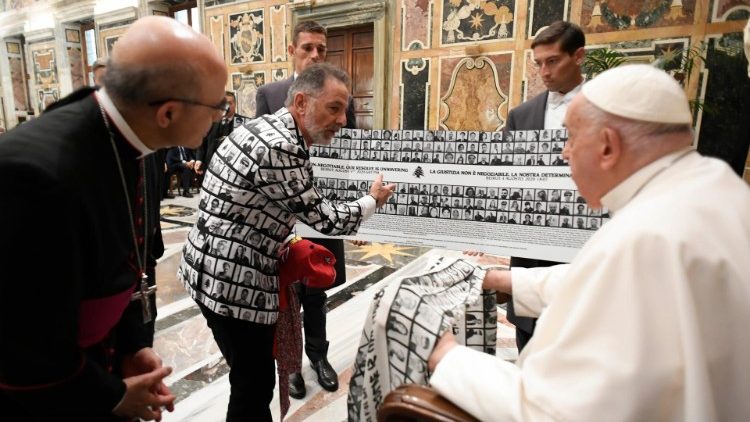 Uno dei partecipanti mostra al Papa i volti delle vittime dell'esplosione al porto di Beirut (4 agosto 2020)  stampati anche su una stola regalata al Pontefice