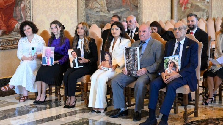 Alcuni familiari con le foto dei loro cari 