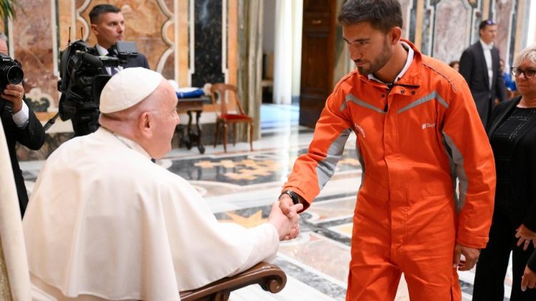 Pope Francis shakes hands with an employee of Terna