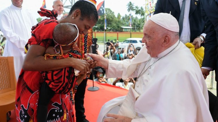 Una mamma col bambino saluta il Papa dopo aver portato con la famiglia la sua testimonianza  a Vanimo