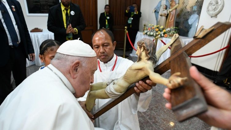 El Papa besa la cruz a su llegada a la catedral de Dili