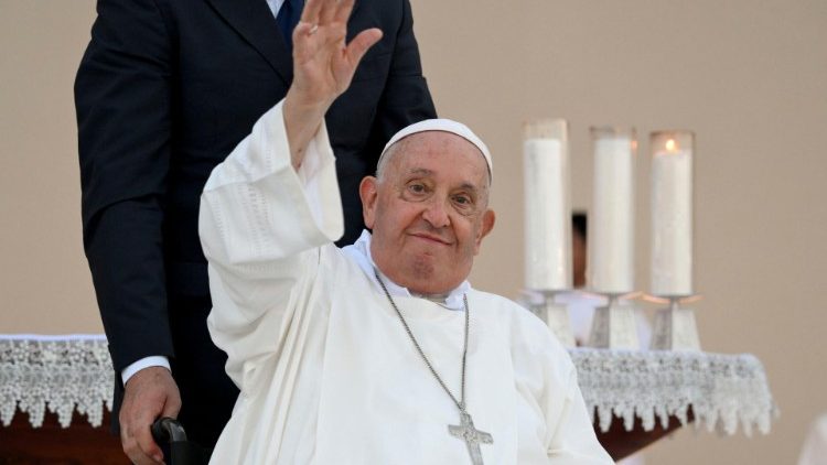 Pope Francis waves as he leaves the altar after Mass