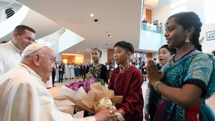 Cuatro niños vestidos con trajes tradicionales dan la bienvenida al Papa a Singapur