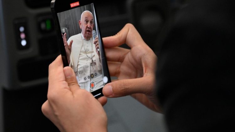 Francesco ripreso dai giornalisti durante la conferenza stampa sull'aereo papale