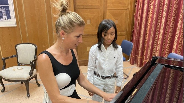 Cecilia Grillo spiega un passaggio al pianoforte al piccolo Luca Capotorto