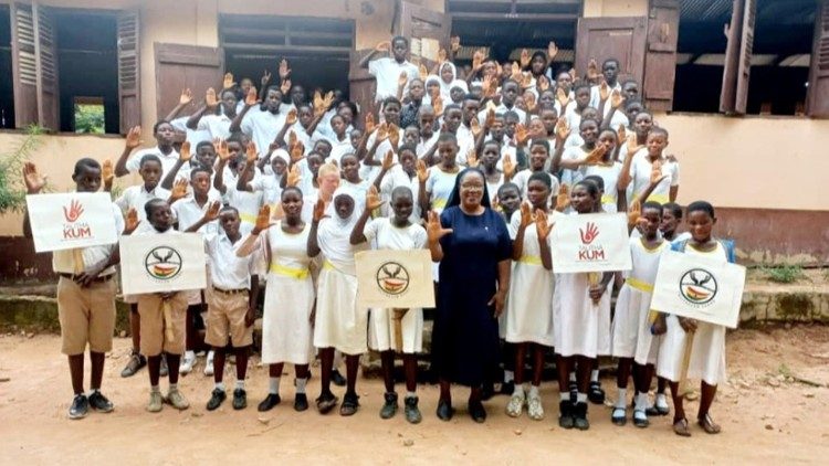 Suor Joy Abuh con gli studenti della St. Michael's Junior High School di Donkorkrom che alzano le mani contro la tratta di esseri umani dopo una lezione di sensibilizzazione presso la scuola il 18 luglio 2024.